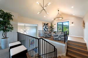 Stairs featuring a chandelier, wood finished floors, recessed lighting, and lofted ceiling