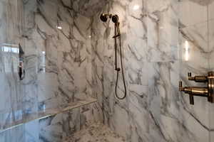 Full bath with a marble finish shower
