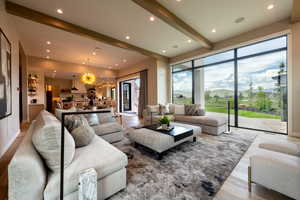 Living room with a chandelier, beam ceiling, recessed lighting, and wood finished floors