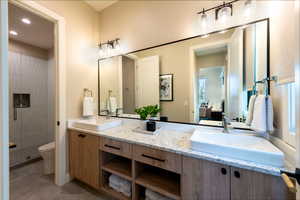 Ensuite bathroom featuring a stall shower, double vanity, tile patterned floors, and recessed lighting