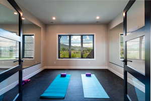 Exercise room featuring recessed lighting and dark colored carpet