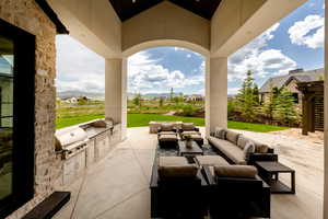 View of patio / terrace featuring exterior kitchen, an outdoor hangout area, and a mountain view