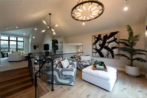 Living area featuring a chandelier, vaulted ceiling, wood finished floors, and recessed lighting
