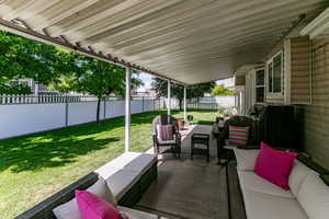 Fenced backyard with an outdoor living space and a patio area