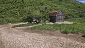 View of yard featuring a storage shed and a wooded view