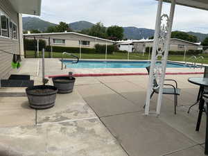 View of pool with a mountain view and a patio area