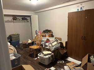 Bedroom with wood finished floors and a closet