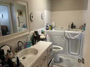 Full bathroom with a bath, vanity, toilet, and tasteful backsplash