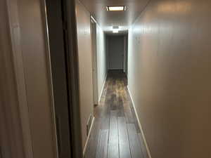 Hall featuring dark wood finished floors and baseboards