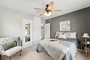 Bedroom with light carpet and a ceiling fan