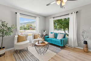 Living room with wood finished floors, ceiling fan, and a mountain view