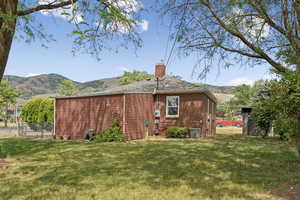 Back of house with a chimney, a mountain view, and brick siding