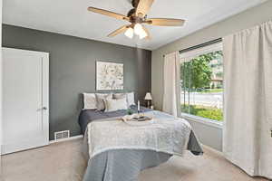 Bedroom featuring carpet flooring, multiple windows, and ceiling fan