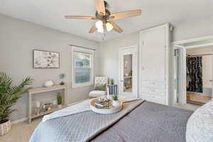 Bedroom featuring light colored carpet, a ceiling fan, and ensuite bathroom