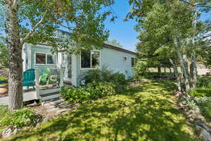 View of side of property with a yard and a wooden deck