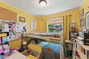 Bedroom featuring a textured ceiling and ornamental molding
