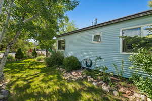 View of side of home featuring a yard