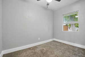 Carpeted spare room with a ceiling fan and a textured ceiling
