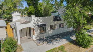 View of front of home featuring stucco siding and a chimney
