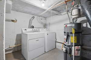 Laundry room with strapped water heater and washing machine and dryer