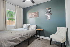 Bedroom featuring carpet, a ceiling fan, and a textured wall
