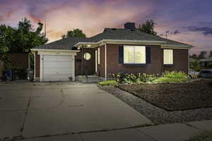 View of front of house featuring driveway, an attached garage, brick siding, and roof with shingles
