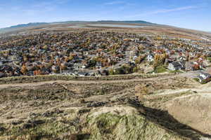Aerial view of property and surrounding area with mountains and nearby suburban area