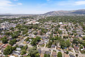 Aerial view of property and surrounding area with a mountainous background and nearby suburban area