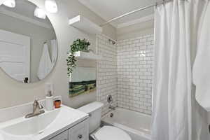 Full bathroom with vanity, ornamental molding, and shower / bath combo