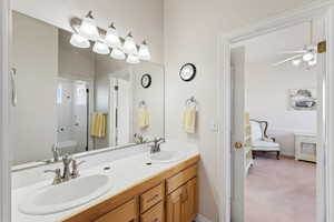 Full bath featuring double vanity, a ceiling fan, and shower / bathtub combination