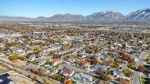 Aerial view of property and surrounding area featuring a mountain backdrop and nearby suburban area