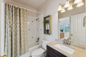 Bathroom with shower / bath combination with curtain and vanity