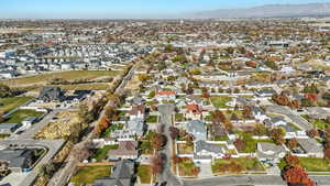 Aerial view of property and surrounding area featuring mountains and nearby suburban area