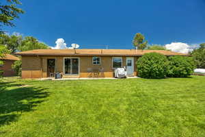 Back of house with brick siding, entry steps, and a patio