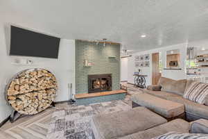 Living room with a textured ceiling and a fireplace