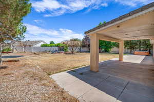 Fenced backyard with a playground and a patio