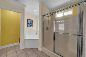 Bathroom with a garden tub, a shower stall, and tile patterned floors