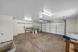 Garage featuring a garage door opener and baseboards