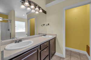 Full bath featuring double vanity, a bath, tile patterned flooring, and a shower stall