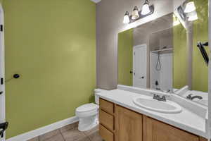 Full bath with vanity, tile patterned flooring, and a shower