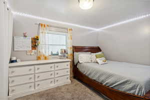 Bedroom featuring light carpet