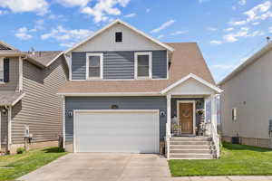 View of front facade featuring roof with shingles, a garage, board and batten siding, concrete driveway, and a front lawn