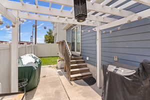 Fenced backyard with area for grilling, a pergola, and a patio