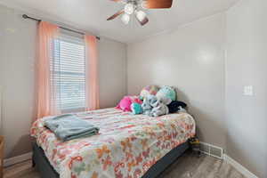 Bedroom featuring wood finished floors and a ceiling fan