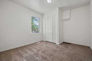 Unfurnished bedroom featuring carpet and a closet