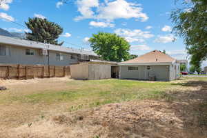 View of yard with a storage unit and an AC wall unit