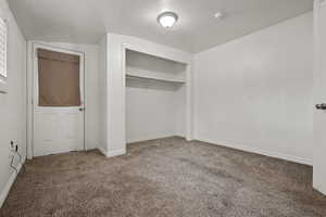 Unfurnished bedroom featuring carpet flooring and a closet