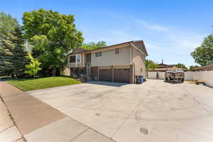 Raised ranch featuring a garage and driveway