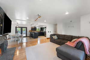 Living area with light wood-style floors, recessed lighting, and a fireplace