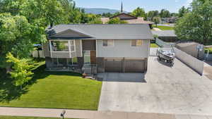 Split foyer home with driveway, roof with shingles, and a garage